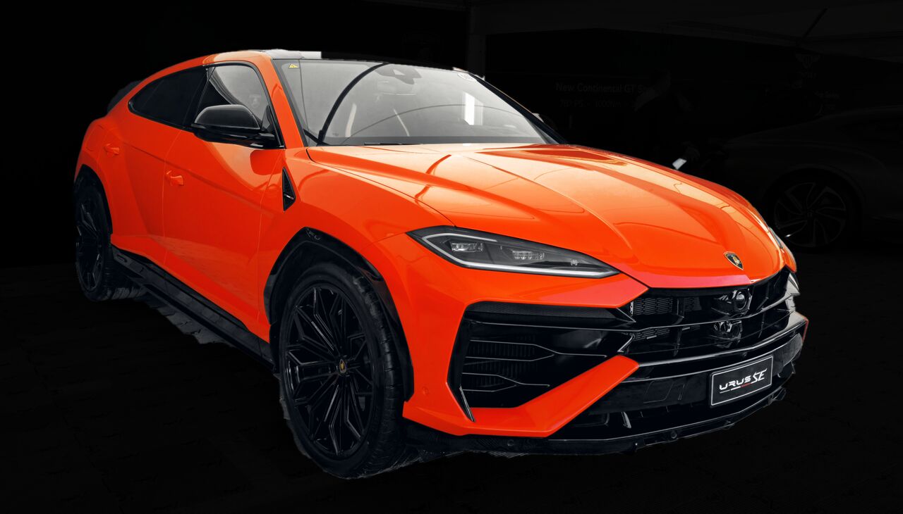 Lamborghini Urus SE laranja visto de frente, sobre fundo escuro